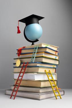 vista-frontal-libros-apilados-gorro-graduacion-escaleras-dia-educacion_23-2149241014